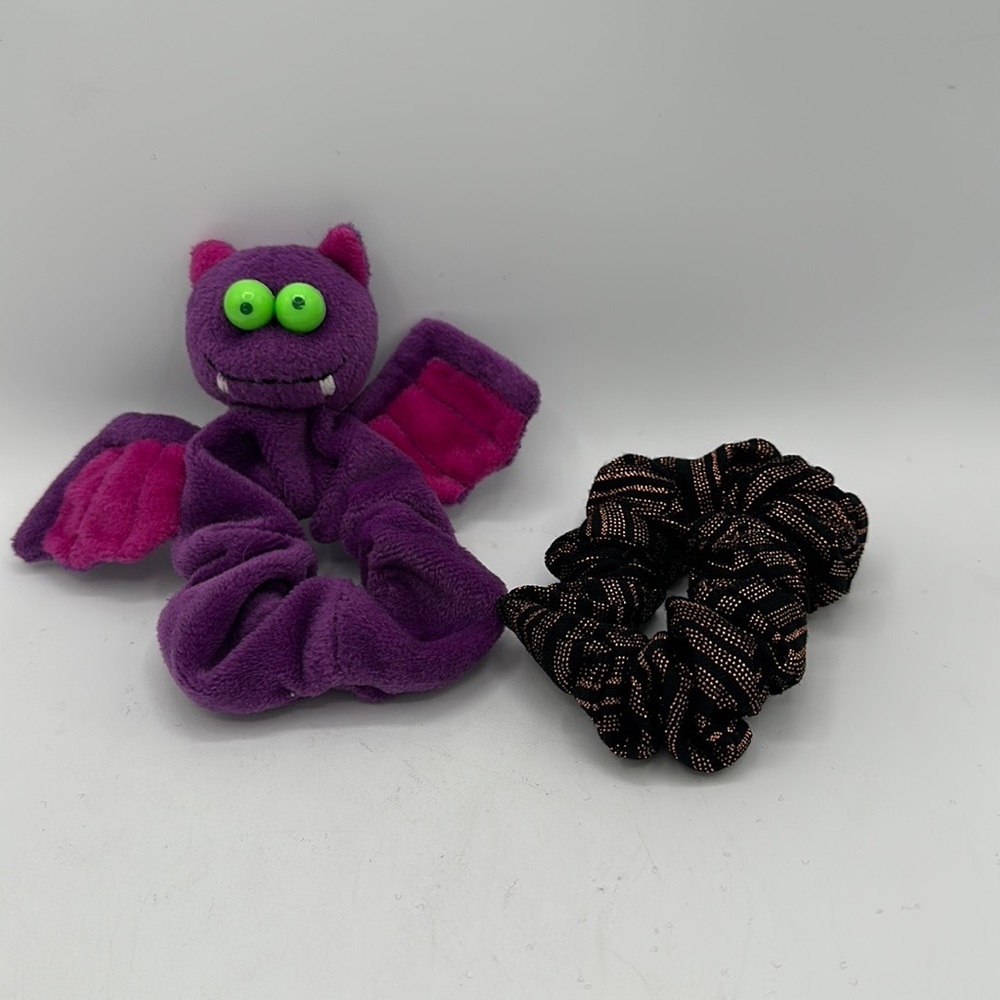 Hair scrunchies: one bat-shaped and one black/copper